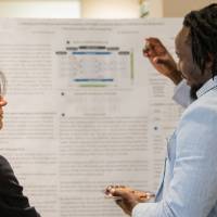Samuel explaining his research to Provost Fatma Mili